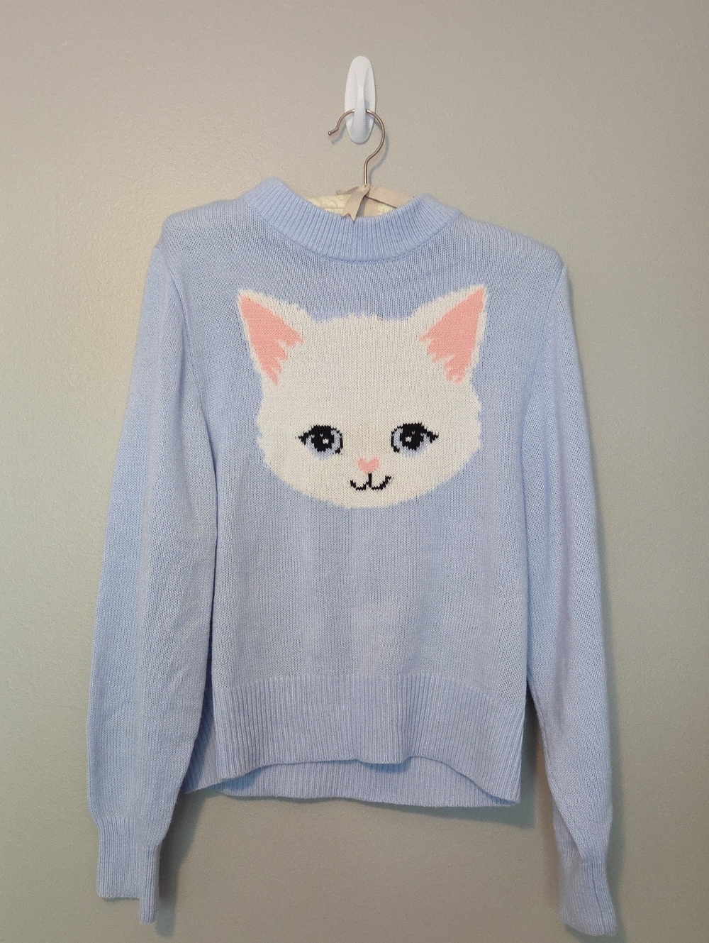 Divided Light Blue Crewneck Sweater with White Cat Face and Pink Accents